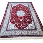 Persian Nain red machine made carpet 300x200cm featuring an ivory floral medallion and traditional cream and blue borders